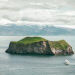 View over the small island and a boat next to Westman Islands in south Iceland