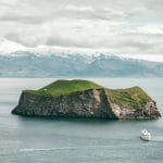 View over the small island and a boat next to Westman Islands in south Iceland