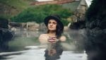 woman sitting in Hrunalaug hot spring in the Golden Circle Iceland