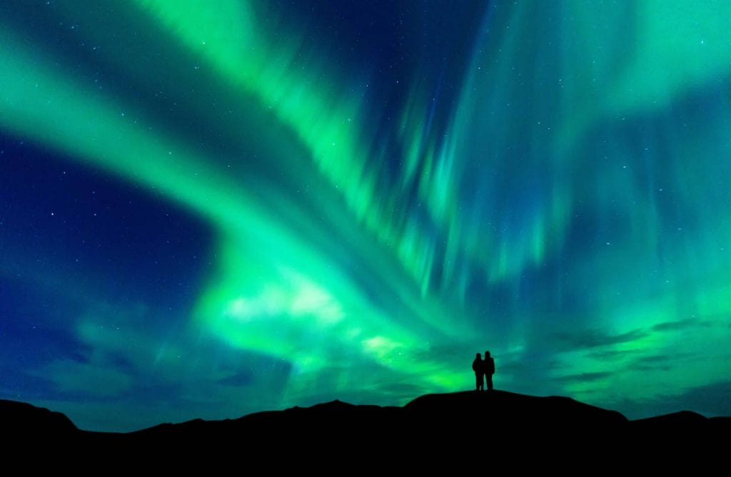 Aurora Tours, Northern Lights Tours in Iceland, Northern Lights Iceland | Iceland Travel Guide, two people watching the Northern Lights in Iceland