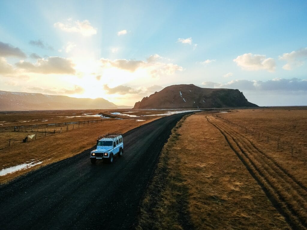 white jeep driving in a sunset in Iceland