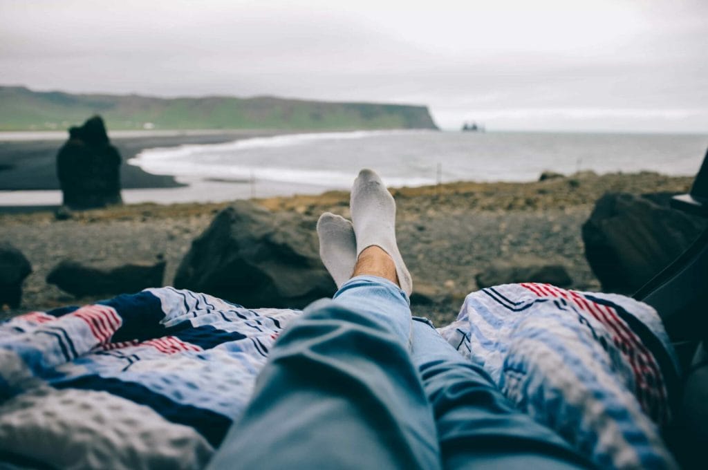 relaxing in the back of a camper van with a view over Reynisfjara black sand beach in South Iceland