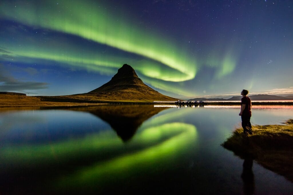 Northern Lights Iceland | Iceland Travel Guide, northern lights aurora borealis dancing over Kirkjufell mountain and Kirkjufellsfoss waterfall in Snæfellsnes Peninsula