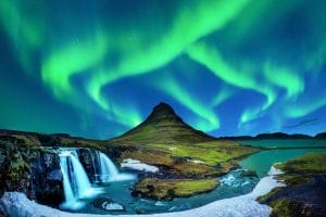 northern lights aurora borealis dancing over Kirkjufell mountain and Kirkjufellsfoss waterfall in Snæfellsnes Peninsula