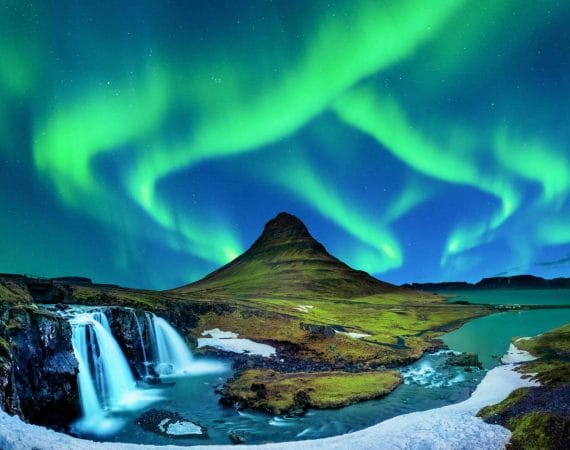 northern lights aurora borealis dancing over Kirkjufell mountain and Kirkjufellsfoss waterfall in Snæfellsnes Peninsula