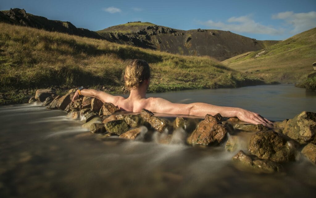 Iceland Hot Springs, hot springs in Iceland, man sitting in Reykjadalur hot spring on the Reykjadalur hot spring and hike