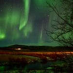 northern lights above Krauma natural baths in west Iceland