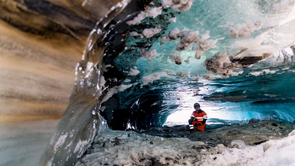 man sitting inside Langjokull natural ice cave