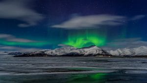 northern lights dancing above a mountain in Iceland