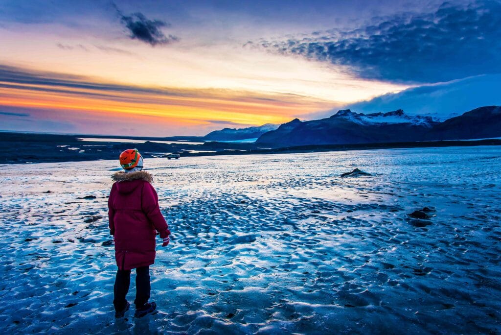 man standing in front of a glacier during winter in Iceland