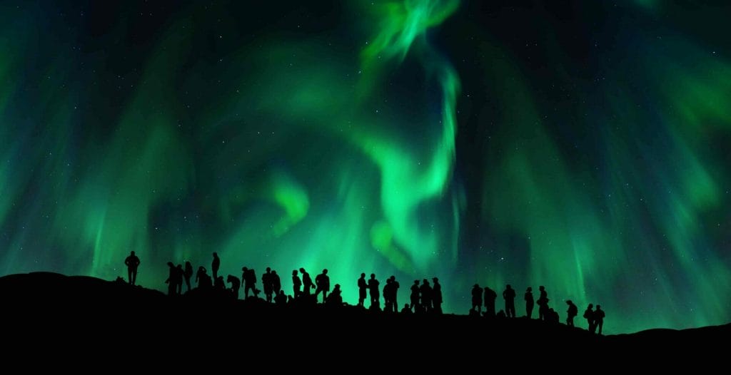 a group of people watching the northern lights in Iceland