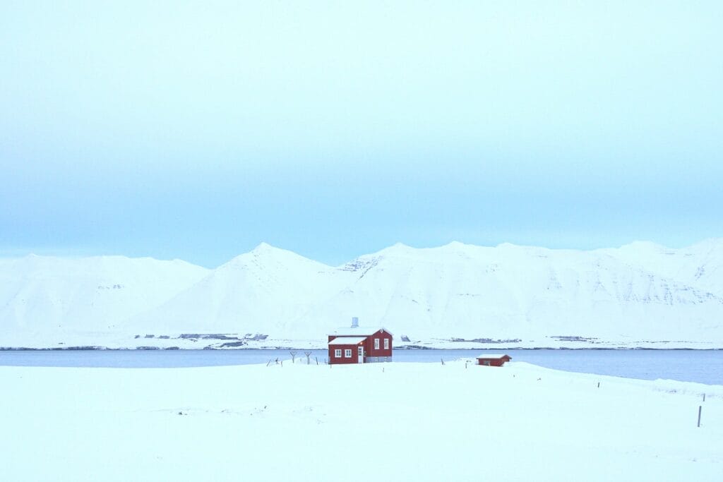 red house standing alone in the snow in Dalvík village in north Iceland