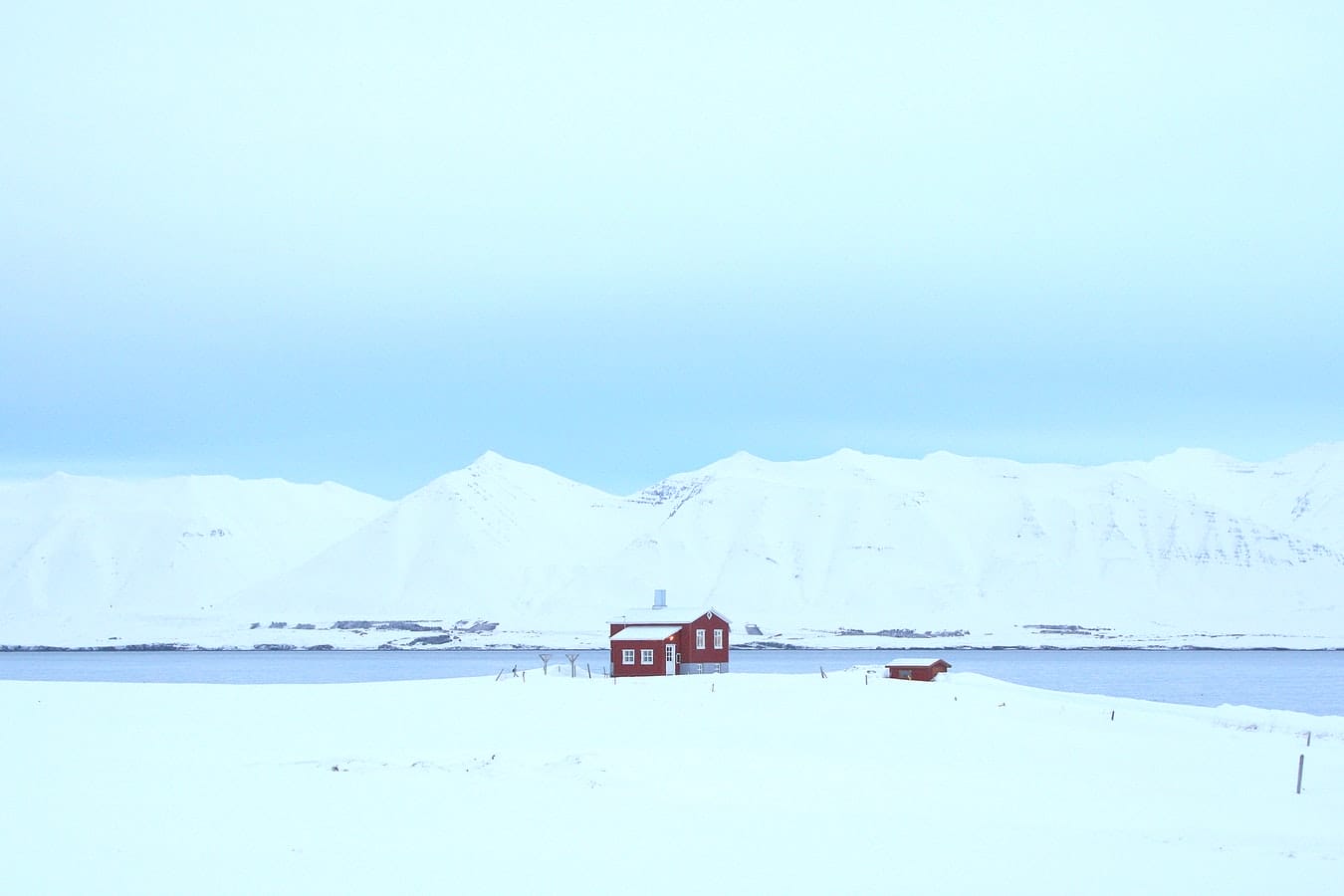 red house standing alone in the snow in Dalvík village in north Iceland