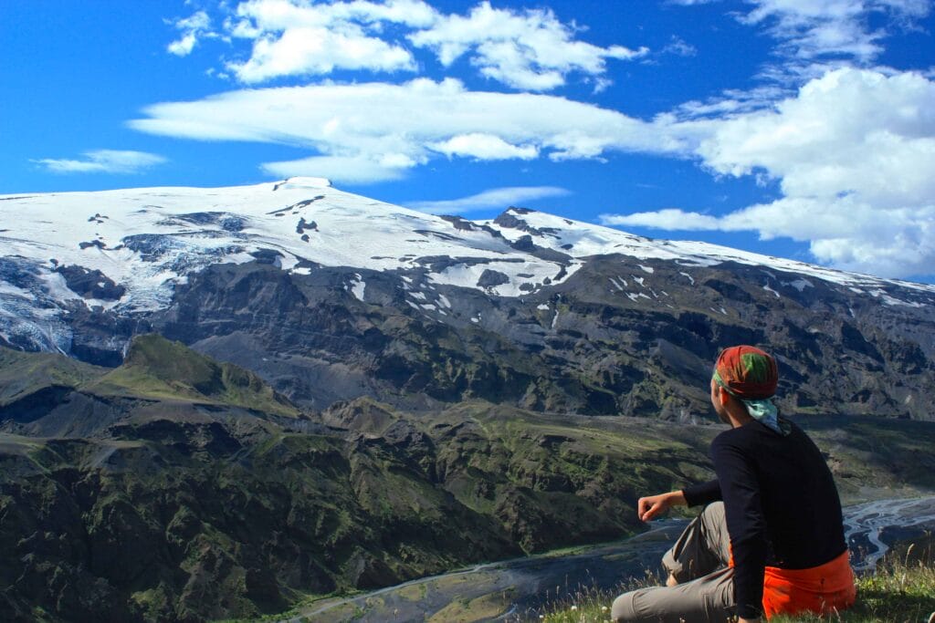 man sitting with a view over Eyjafjallajokull volcano and mountain in Iceland