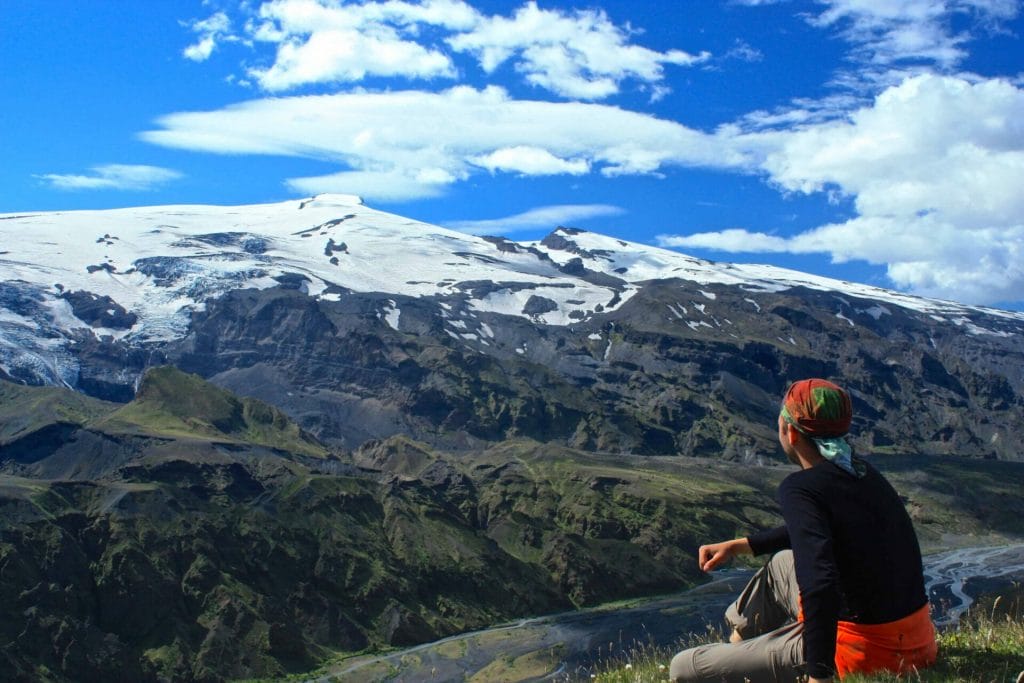 man sitting with a view over Eyjafjallajokull volcano and mountain in Iceland
