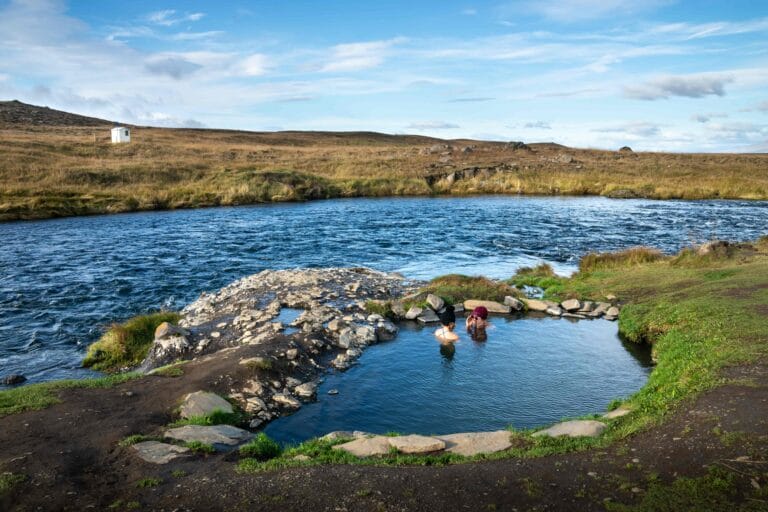 Iceland hot spring, two people bathing in Fosslaug hot spring in north Iceland