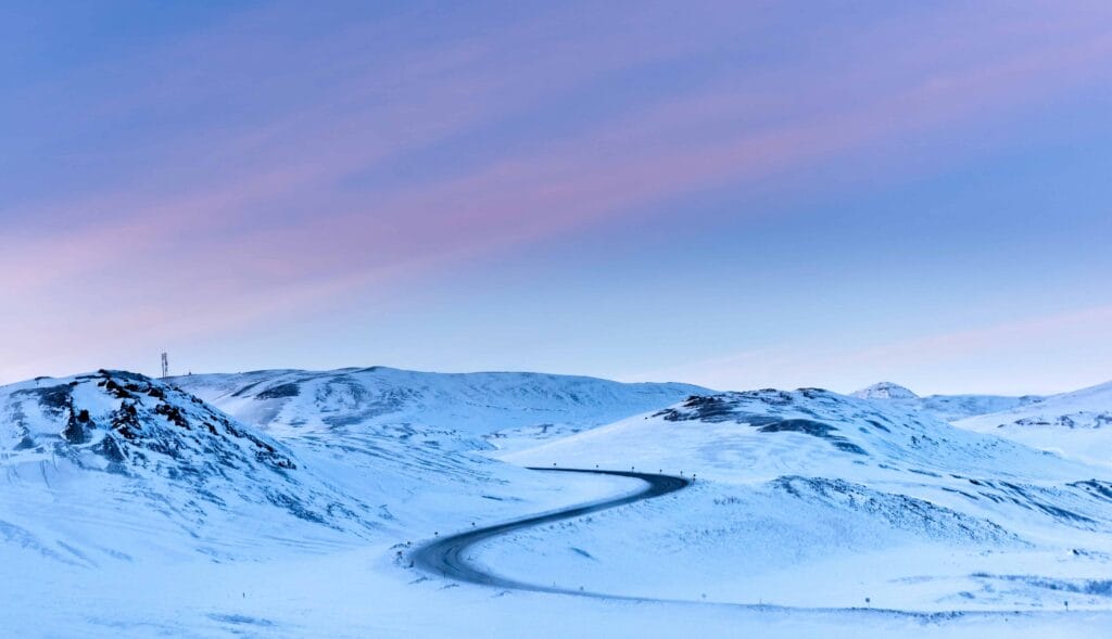 winter road trip in Iceland in snow and pink skies