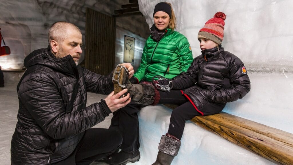 a group of people visiting into the glacier ice cave in Langjokull