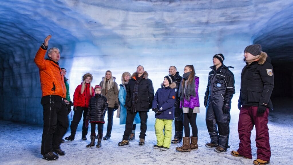 a group of people visiting into the glacier ice cave in Langjokull
