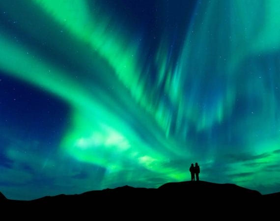 Honeymoon in Iceland, two people watching the northern lights in Iceland