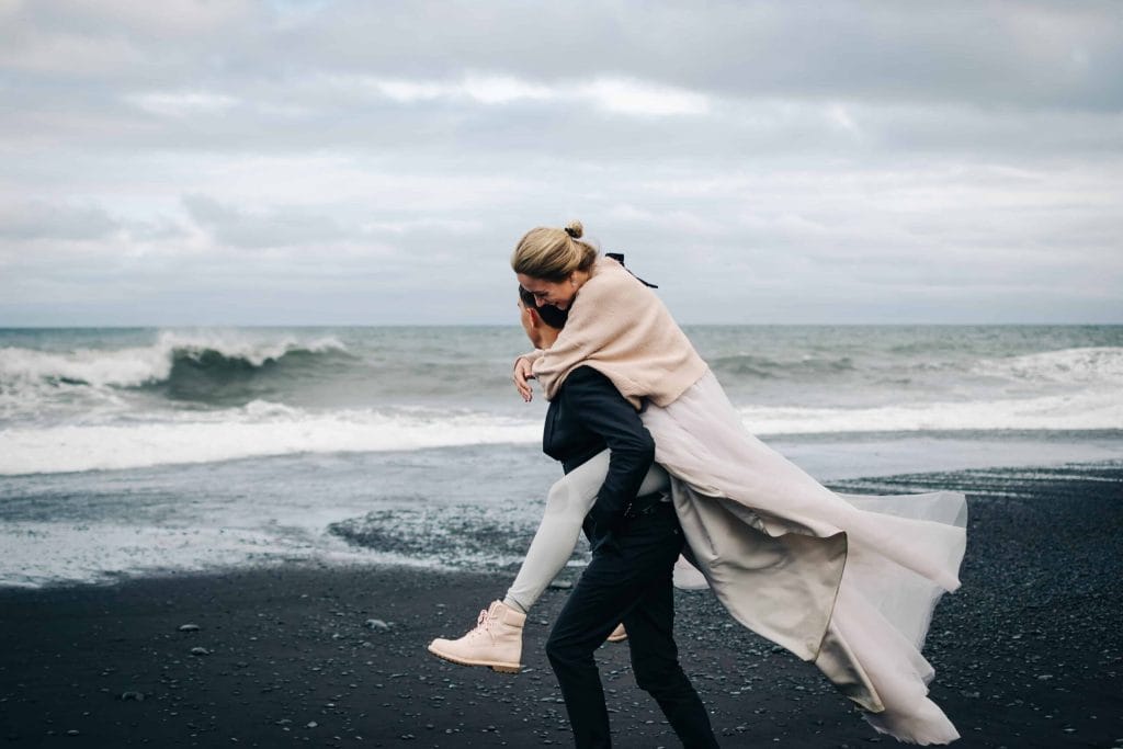 Honeymoon in Iceland, couple on the black sand beach in Iceland