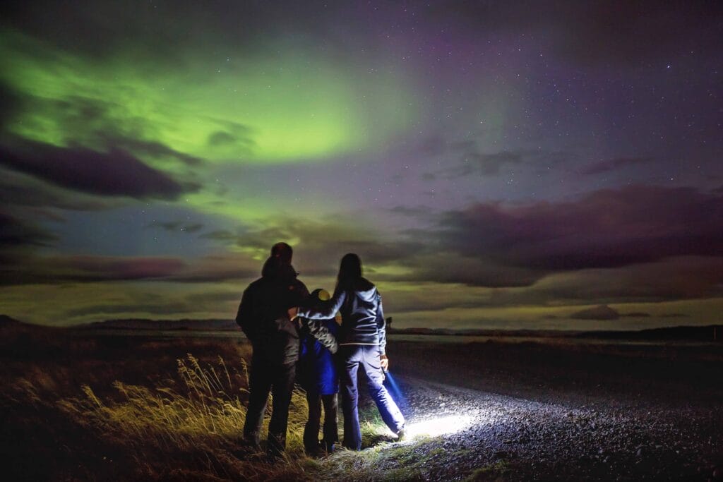 Family watching the northern lights in Iceland