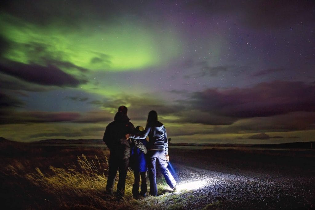 Family watching the northern lights in Iceland