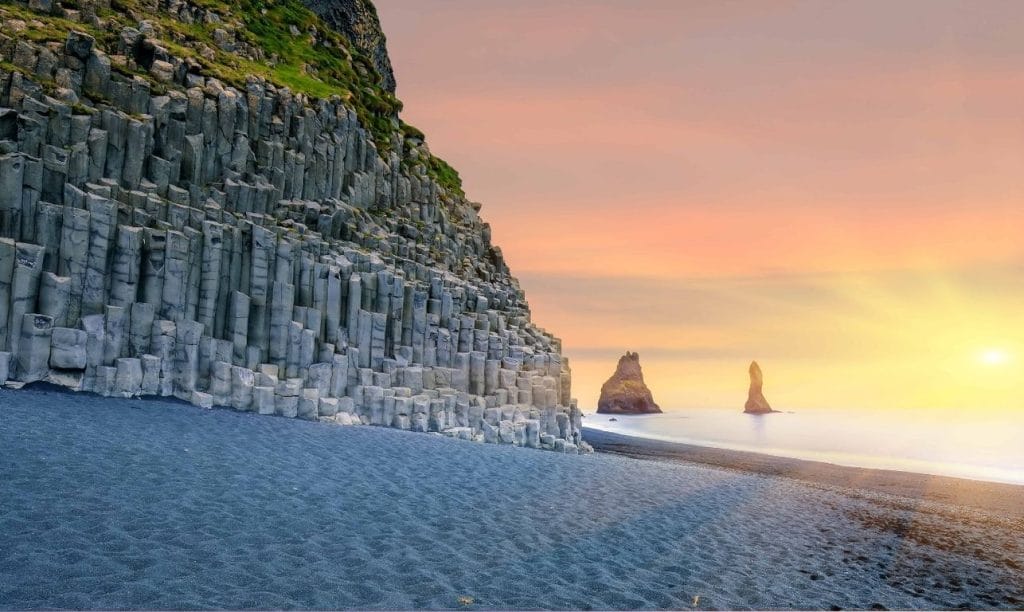 sunset at Reynisfjara black sand beach and Reynisdrangar basalt columns at sunset