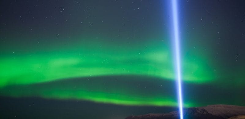 Northern Lights dancing above the skies and the peace tower on the Northern Lights Luxury Cruise tour