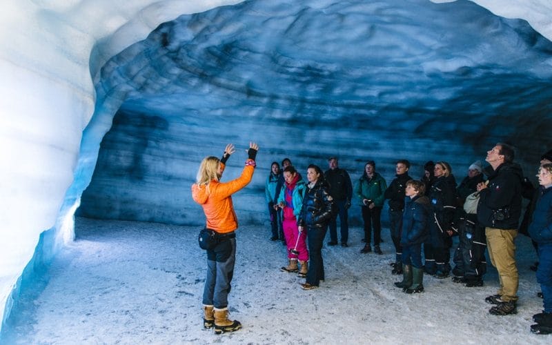 a group of people visiting into the glacier ice cave in Langjokull