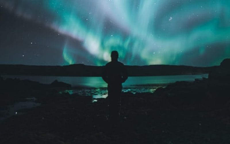 man watching the northern lights in Iceland