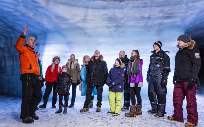 a group of people visiting into the glacier ice cave in Langjokull
