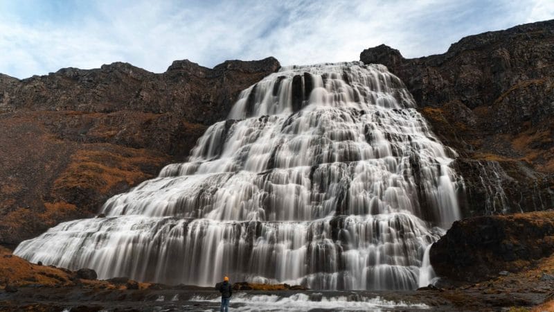man standing in front of Dynjandi waterfall in the Westfjords