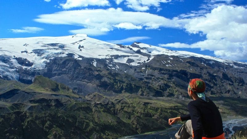 man sitting with a view over Eyjafjallajokull volcano and mountain in Iceland