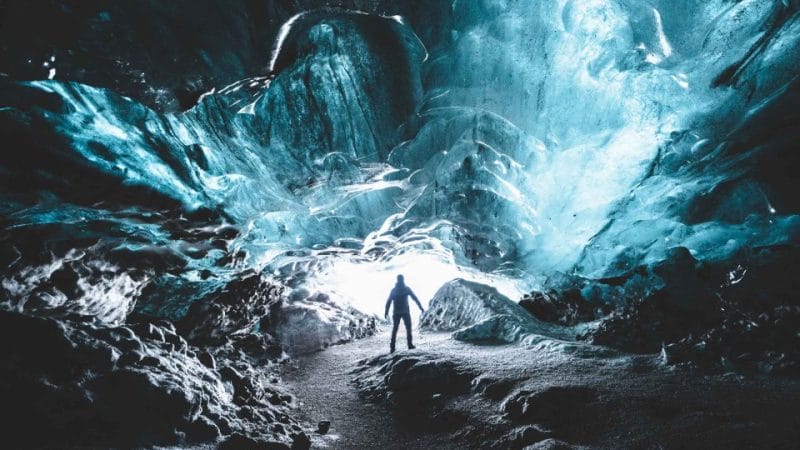 Katla Ice Cave, Ice Cave Tours, a man standing inside Katla Ice Cavel the best summer self driving tours in Iceland