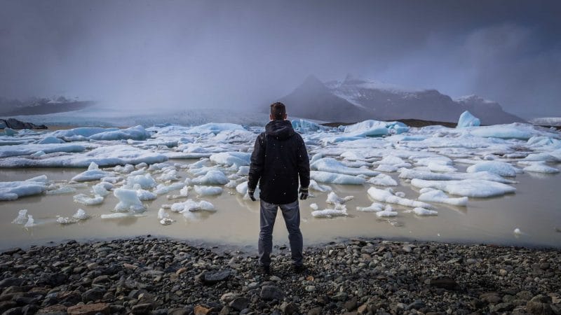 Man Standing in Front of Fjallsárlón Glacier Lagoon - South Iceland Tours
