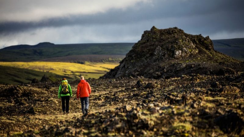 two people walking over lava fields in the highlands of Iceland