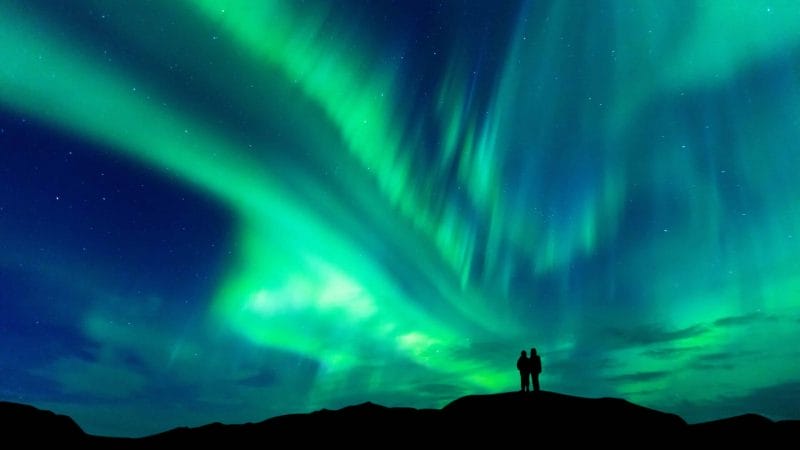 Honeymoon in Iceland, two people watching the northern lights in Iceland