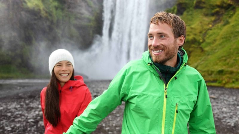 Honeymoon in Iceland, couple in front of Skógafoss waterfall