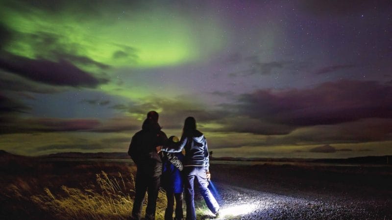 Family watching the northern lights in Iceland