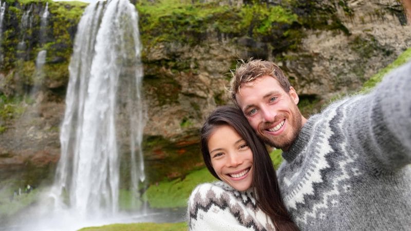 Honeymoon in Iceland, couple in front of Seljalandsfoss waterfall