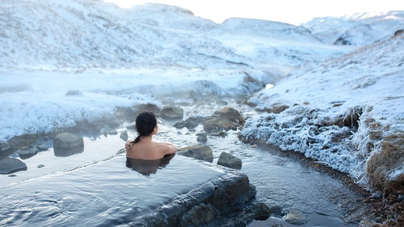 Iceland Hot Springs, hot springs in Iceland, The girl bathes in a hot spring in the open air with a gorgeous view of the snowy mountains. Incredible iceland in winter, Hrunalaug hot spring in the golden circle in Iceland