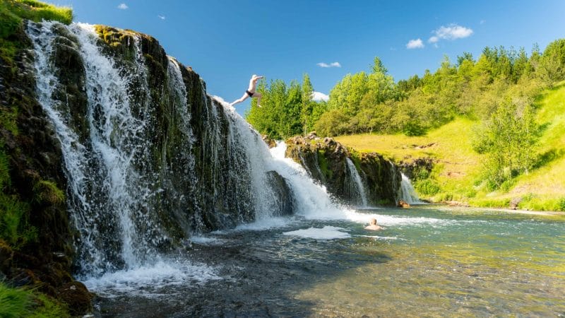 Iceland Family Travel, jumping into a waterfall in Iceland