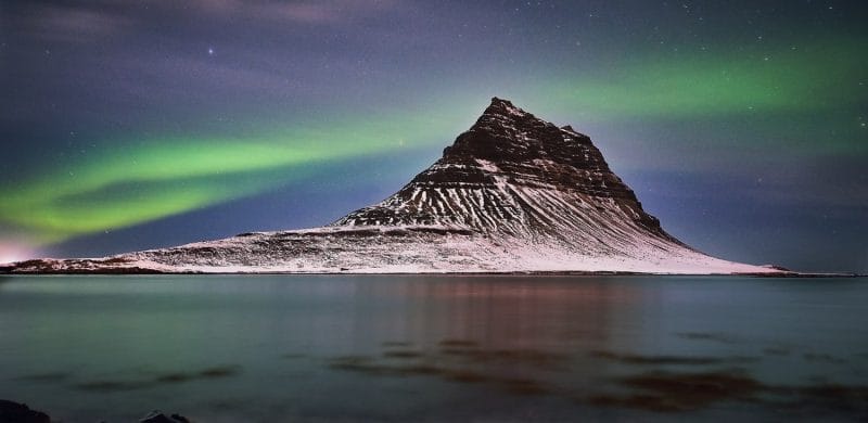 northern lights aurora borealis dancing over Kirkjufell mountain and Kirkjufellsfoss waterfall in Snæfellsnes Peninsula