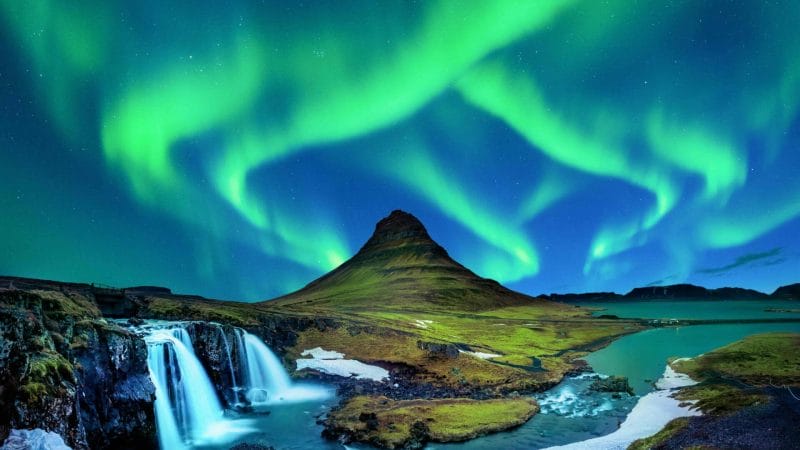 northern lights aurora borealis dancing over Kirkjufell mountain and Kirkjufellsfoss waterfall in Snæfellsnes Peninsula