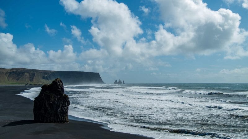 Kirkjufjara black sand beach and Eagle Rock in south Iceland with views over to Reynisfjara and Reynisdrangar