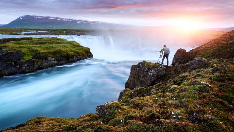 Photography in Iceland - man capturing Goðafoss waterfall on a photo