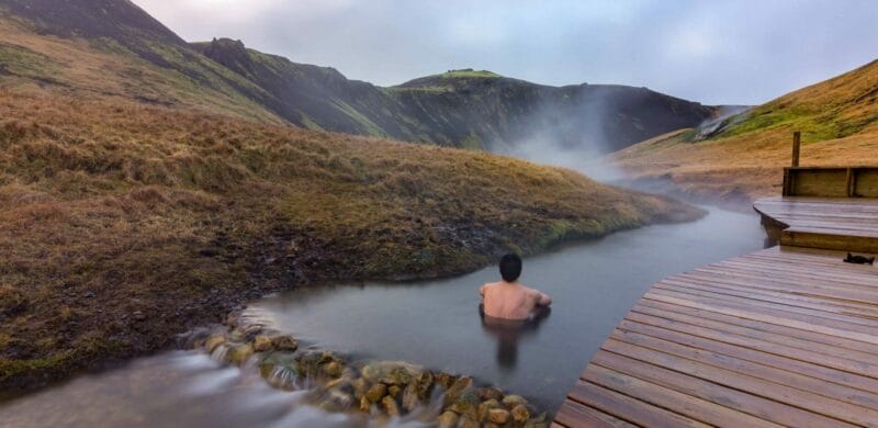 Iceland Hot Springs, hot springs in Iceland, man sitting in Reykjadalur hot spring on the Reykjadalur hot spring and hike