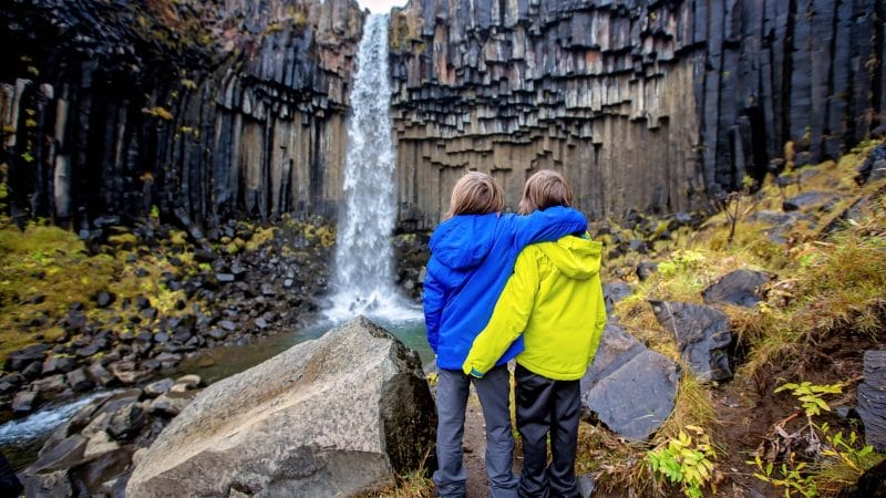 brothers at Svartifoss waterfall in Skaftafell Vatnajökull National Park in south Iceland
