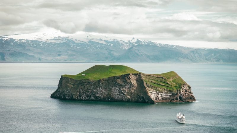 View over the small island and a boat next to Westman Islands in south Iceland